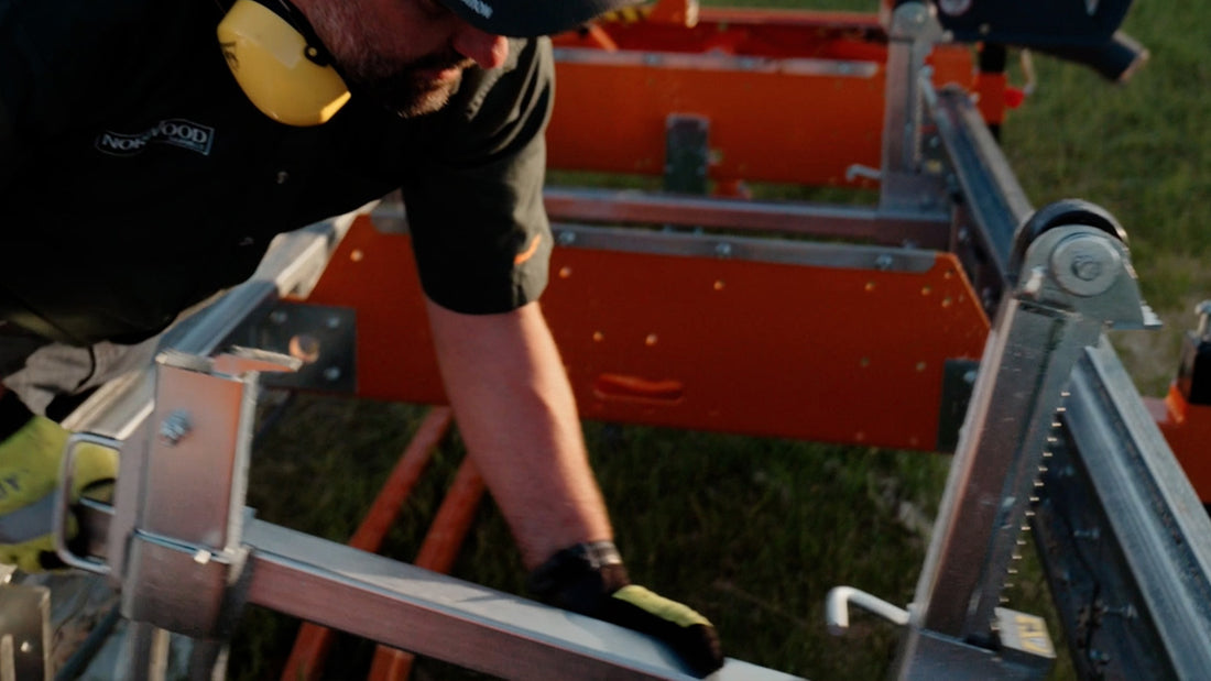 Laterally movable log clamping stations